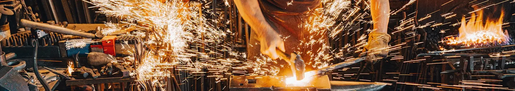 En smed som arbetar med glödande metall