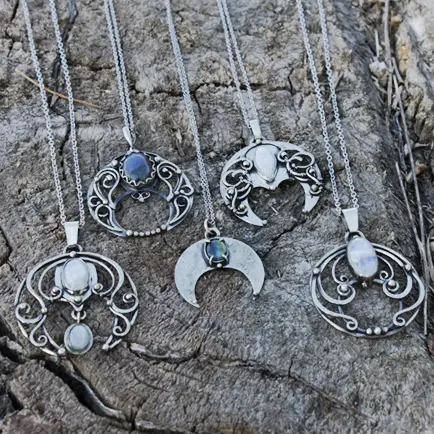 Detaljerade silverhalsband med ädelstenar på ett stenblock