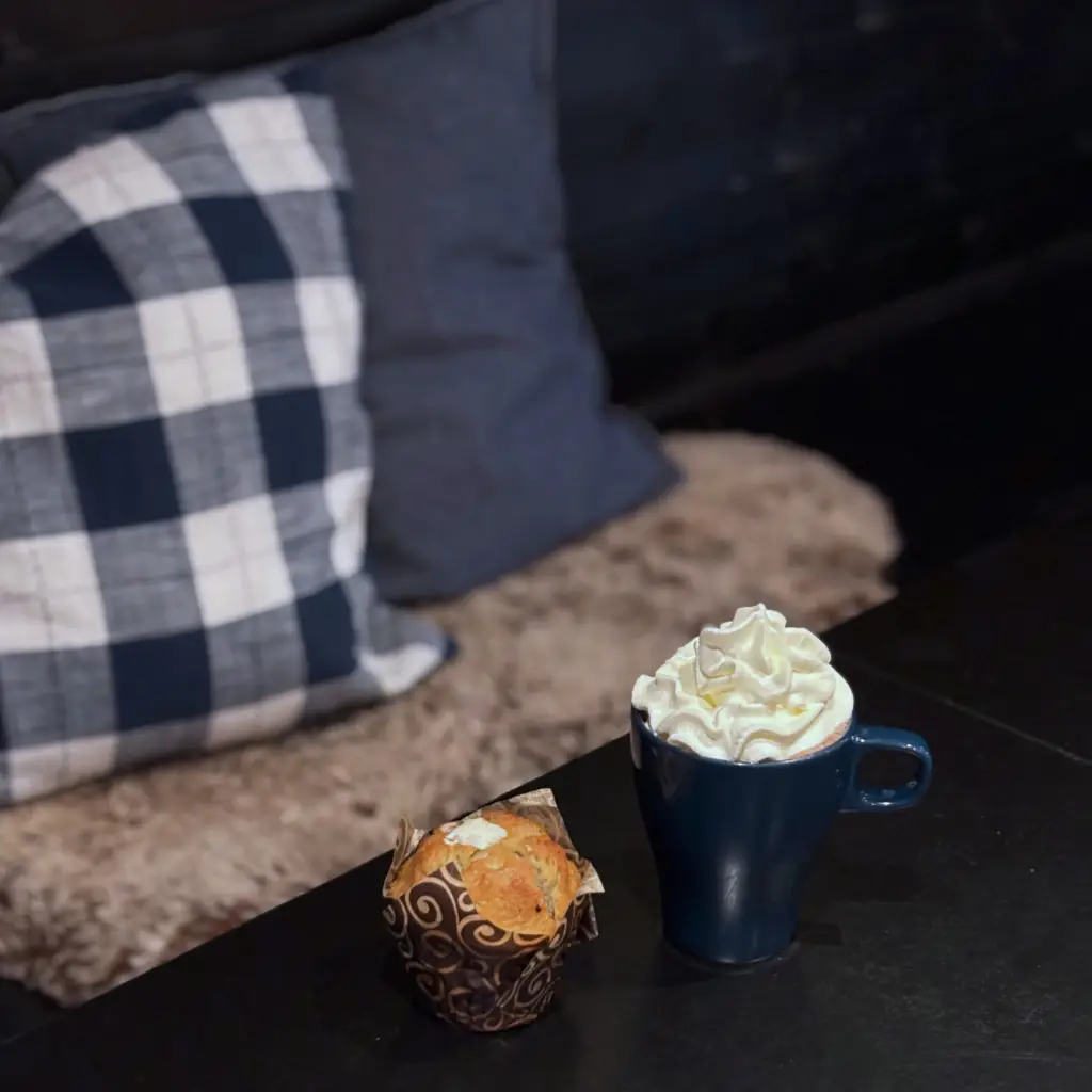 Varm choklad med grädde och muffin i caféet